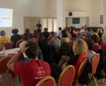 Grupo de personas participando en una presentación durante el curso internacional de Trail Orienteering organizado por COCEMFE en Chipre, en el marco del proyecto IOFA.