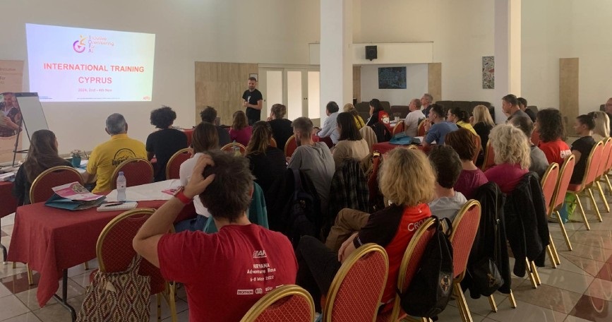 Grupo de personas participando en una presentación durante el curso internacional de Trail Orienteering organizado por COCEMFE en Chipre, en el marco del proyecto IOFA.