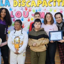 Alumnos y docentes del CEIP Miquel Aldret i Noguerol mostrando el mural pintado sin manos, parte de la sensibilización sobre discapacidad