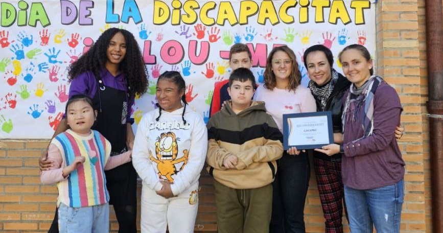 Alumnos y docentes del CEIP Miquel Aldret i Noguerol mostrando el mural pintado sin manos, parte de la sensibilización sobre discapacidad