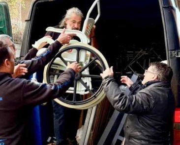 Presidente de COCEMFE Barcelona descargando material ortopédico con personas voluntarias