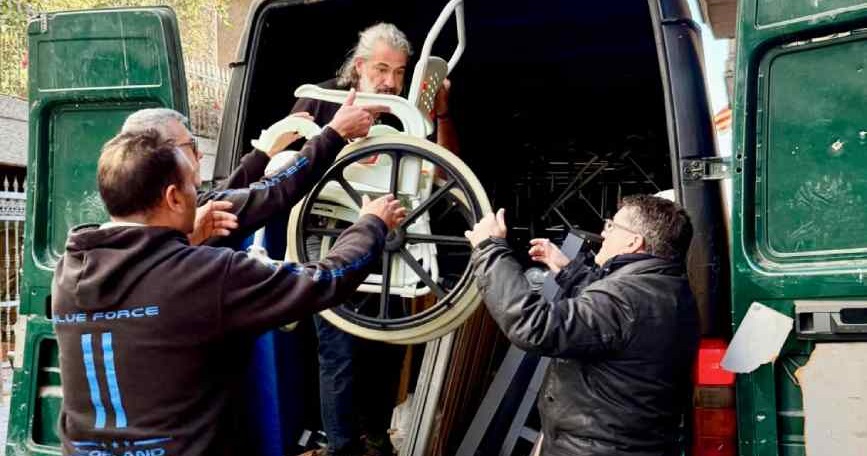 Presidente de COCEMFE Barcelona descargando material ortopédico con personas voluntarias